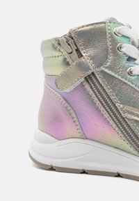 Holografischer High-Top-Sneaker mit einer strukturierten Silberoberfläche, weißen Schnürsenkeln und einem seitlichen Reißverschluss für ein einfaches Anziehen, ausgestattet mit einer gepolsterten Sohle.