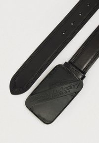 Μαύρη δερμάτινη ζώνη με λεία υφή, που διαθέτει ορθογώνια αγκράφα λογοτύπου με ανάγλυφο το κείμενο "Diesel Industry Denim Division".