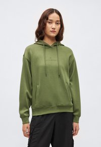 Olivovozelená mikina s kapucňou na šnúrku, prednými vreckami a rebrovanými manžetami. Hladká textúra a vyšívaný detail na hrudi.