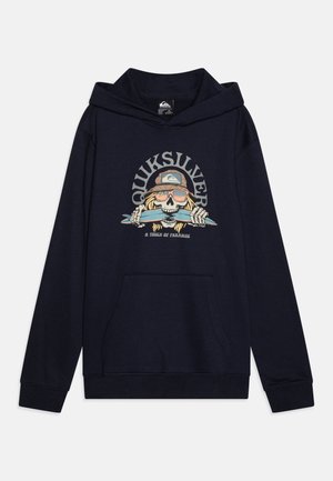 Marineblå hættetrøje med frontlomme, med et kranie iført solbriller og kasket, der bider i et surfbræt, med teksten "Quiksilver" og "A Touch of Paradise".