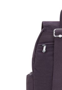 Lila tygryggsäck med texturerad yta, sidoficka med dragkedja och justerbar rem med metallisk detalj.