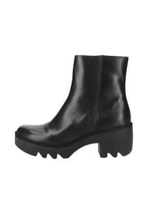 Bota de cuero negra hasta la mitad de la pantorrilla con una suela gruesa y robusta, tacón bloque y un sutil detalle de insecto en relieve en el lateral.