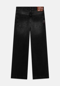 Jeans larghi in denim nero con tasche posteriori, leggera usura e un'etichetta in pelle sulla vita. Design a gamba dritta.