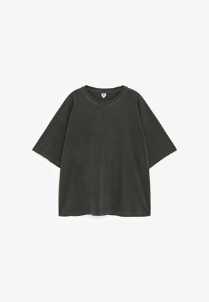 Temno siva prevelika majica s kratkimi rokavi in okroglim izrezom ter vidnimi šivi, položena na ravno belo podlago.