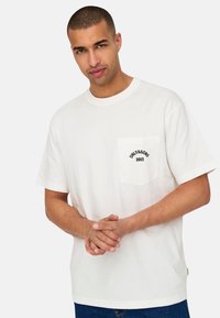 Witte katoenen t-shirt met een ronde halslijn en korte mouwen. Bevat een borstzak met "ONLY & SONS 2013" in het zwart bedrukt.