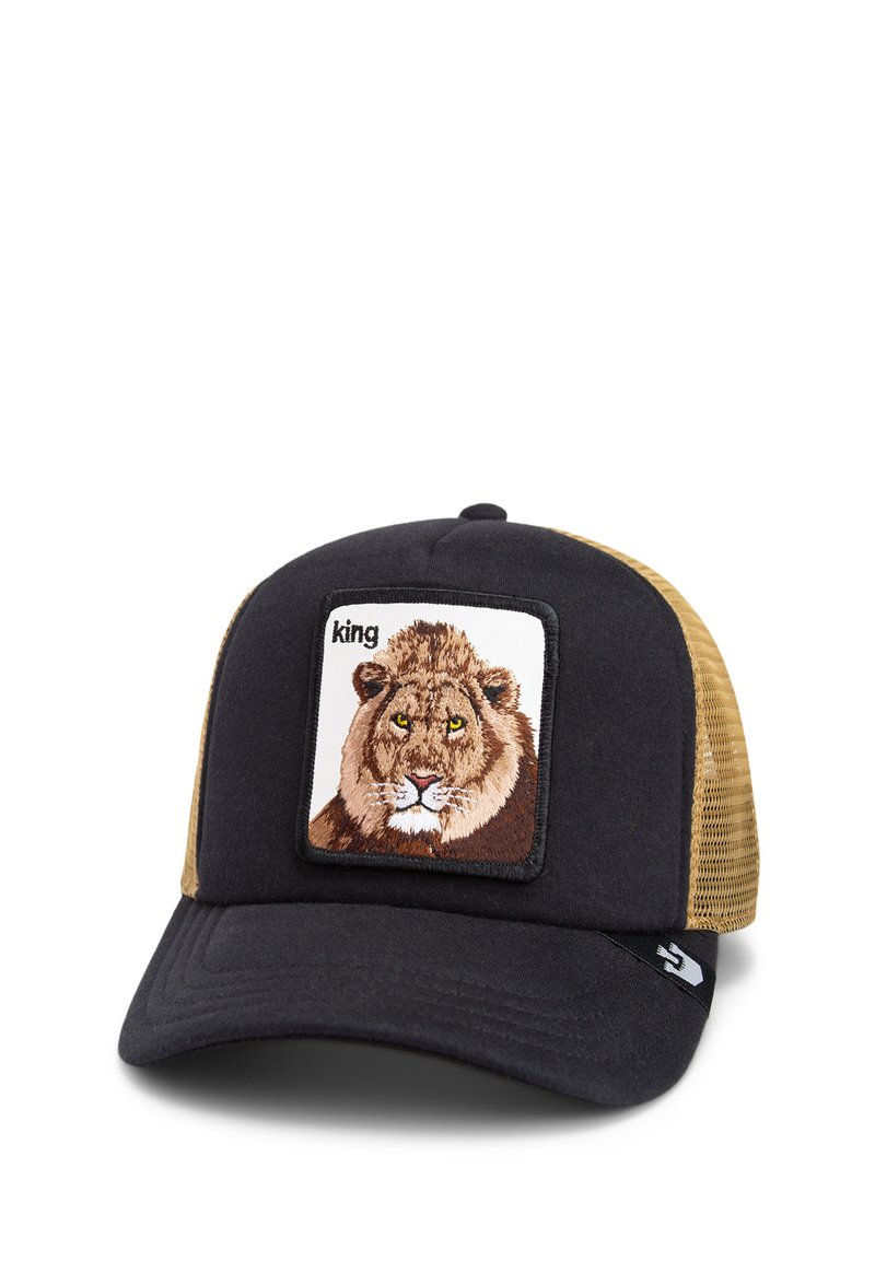Casquette trucker noire et beige avec un patch carré brodé d'un lion, entouré de noir. La visière est plate avec un tissu texturé.