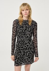 Zwarte jurk met lange sheer mouwen, voorzien van een gerimpeld ontwerp en een wit handgeschreven patroon over de hele jurk. Aansluitende silhouet met een ronde halslijn.