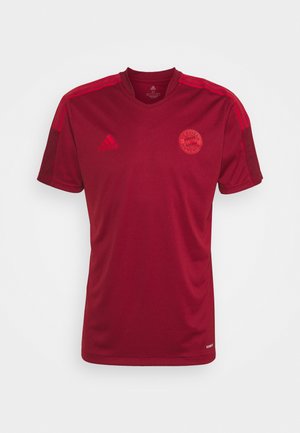 Rode sportshirt met korte mouwen, gemaakt van ademend materiaal, met een v-hals, horizontale strepen op de schouders en een teamlogo op de borst.