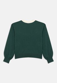 Zöld kötött pulóver kerekített krém szegéllyel, puffos hosszú ujjakkal és bordázott mandzsettákkal. Sima textúrájú, kényelmes, bővített szabású.