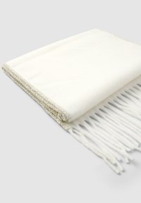 Sciarpa morbida bianca piegata, con frange alle estremità e bordi cuciti, su uno sfondo grigio chiaro.