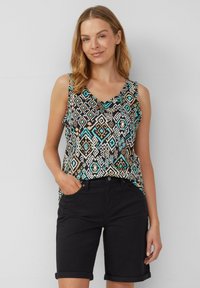 Top senza maniche con scollatura a V, caratterizzato da un motivo geometrico multicolore in turchese, nero e beige. Abbinato a pantaloni corti neri arrotolati.