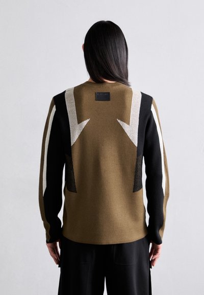 Zöld olíva és fekete színű kötött pulóver fehér nyíl mintákkal a háton; texturált kialakítással és logóval ellátott címkével a nyakrészen.