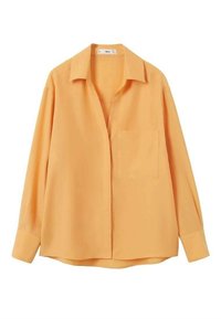 Chemise à manches longues, boutonnée, de couleur orange clair avec un col et une poche poitrine unique, étalée à plat sur fond blanc.
