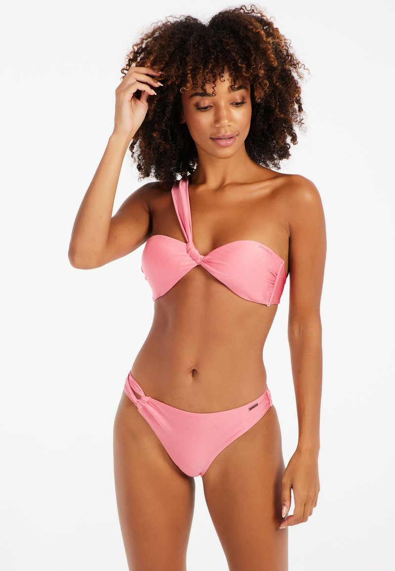Růžový bikini set obsahující top na jedno rameno s uzlem a odpovídající bikini kalhotky s uzlem. Hladká textura s minimálními detaily kovových prvků.