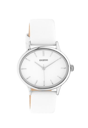 Montre bracelet blanche avec un boîtier rond en acier inoxydable argenté, un cadran blanc minimaliste avec des index d'heure argentés et un bracelet en cuir blanc.