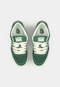Zelené plátěné tenisky so sivými šnúrkami, s textúrovanou špičkou a logom Vans na jazyku a po stranách. Klasický nízky dizajn.