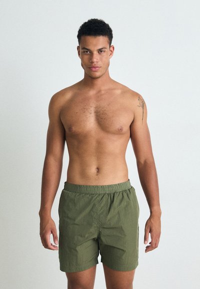 Costume de baie verde realizat din material ușor, cu un brâu elastic. Design simplu, fără modele sau accente suplimentare.