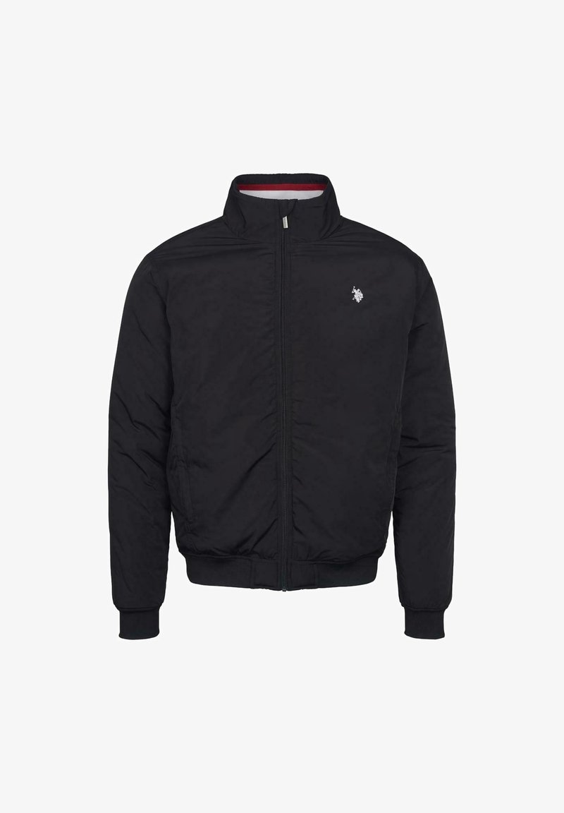 Svart bomberjacka med dragkedja framtill, ribbade muddarna och nederkant. Har en liten broderad logotyp på vänster bröst. Slät tygtextur.