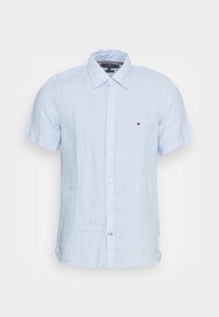 Lichtblauw linnen overhemd met korte mouwen en knopen, met een puntige kraag en een klein logo op de linkerborst.