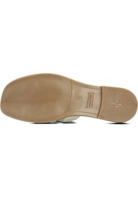 Rubberen zool met een beige textuur, gekenmerkt door een verhoogd ruitpatroon. Etiket en maat "38" in de binnenzool gedrukt.