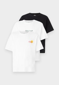 Tre T-shirt maniche corte: una nera, una bianca con il testo "HIDDEN BUNGALOW", una bianca con una grafica "Holidays" in rosso e giallo. Tessuto in cotone.