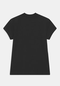 Camiseta negra de manga corta con escote redondo, confeccionada con una tela suave, que presenta un corte holgado y sin detalles de diseño visibles.