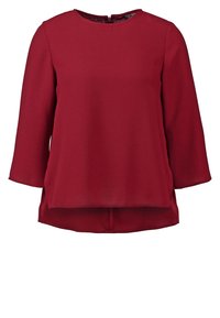 Blusa bordeaux con scollatura rotonda, maniche a tre quarti e retro allungato. Presenta una texture morbida e spacchi laterali per un tocco di stile.
