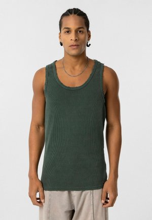 Groene geribde tanktop met een ronde hals en rafelige randen. Heeft een mouwloos ontwerp en een textuurfinish.