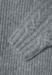 Maglione grigio lavorato a maglia con texture a coste e dettagli a treccia sulle maniche, realizzato in filato morbido.