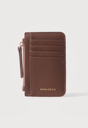 Portofel compact maro cu mai multe sloturi pentru carduri, buzunar cu fermoar și logo auriu „ANNA FIELD” pe față.