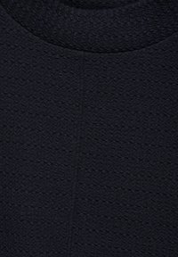 Strukturiertem dunkelblauem Stoff, der ein gewelltes Muster zeigt, mit einem runden Ausschnitt und sichtbaren Nähten im gesamten Material.