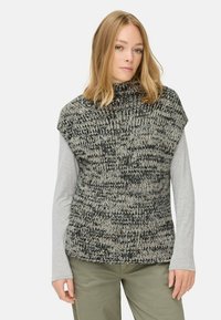 Pull en tricot à col haut, avec un mélange texturé de noir et beige. Assorti avec une chemise à manches longues grise en dessous.