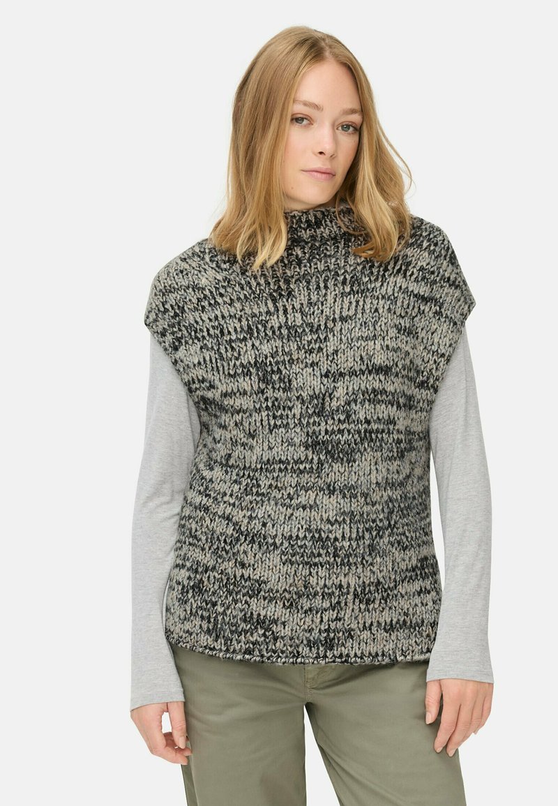 Pull en tricot à col haut, avec un mélange texturé de noir et beige. Assorti avec une chemise à manches longues grise en dessous.