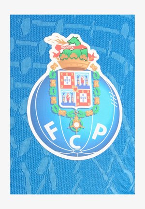 Blå FC Porto fodboldklub emblem med en kronet grøn drage, rød skjold og gyldent laurbærkrans på en struktureret blå stofbaggrund.