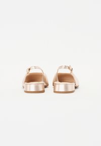 Metallisk roséguld sandaler med låg klack, öppen baksida och rem med en liten spänne-detalj. Slät yta med en minimalistisk design.