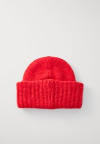 Crvena pletena kapa s rebrastom teksturom i preklopom, napravljena od mekog vune. Glatka površina bez vidljivih uzoraka.