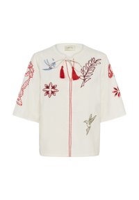 Blusa blanca texturizada con flecos rojos, que presenta flores rojas bordadas, pájaros en azul y oliva, y diseños de hojas rojas en las mangas y el frente.