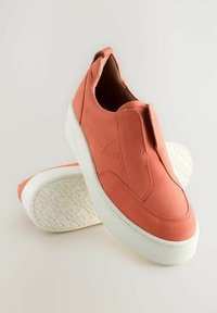 Korall színű, slip-on cipők sima bőr felsőrésszel, fehér gumitalppal, steppelt részletekkel és texturált mintázattal az alján.