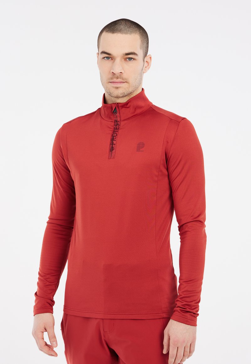 Crvena dugih rukava sportska majica s visokim ovratnikom i četvrtim patentnim zatvaračem. Sadrži suptilan logotip na prsima i elegantnu, glatku teksturu tkanine.