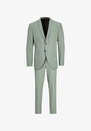 Completo verde chiaro realizzato in tessuto morbido, con giacca a due bottoni e rever a punta, taschino sul petto e pantaloni slim-fit.