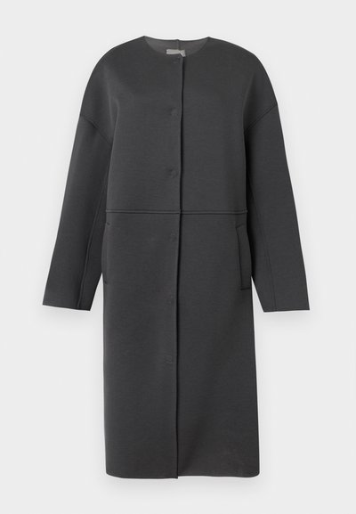 Μακρύ μαύρο παλτό με κουμπιά, στρογγυλή λαιμόκοψη, μακριά μανίκια και πλαϊνές τσέπες, κρεμασμένο σε απλό λευκό φόντο.