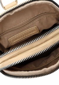 Beige fabric pouch with a zip closure, featuring two interior compartments and a small zipper pocket, with textured lining and hardware accents.