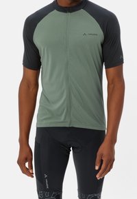 Koszulka rowerowa z krótkim rękawem w oliwkowym kolorze z czarnymi raglanowymi rękawami. Posiada zamek błyskawiczny z przodu oraz logo Vaude na piersi. Gładki, lekki materiał.