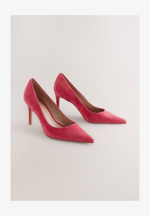 Pink ruskind høje hæle med spids tå-design og en slank stiletthæl, med en glat inderside og uden synligt metalhardware.