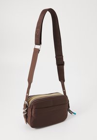 Borsa a tracolla in tessuto marrone con zip dorata e accessori neri. Presenta una tracolla regolabile con motivo e una tasca frontale.
