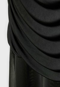Gros plan sur un tissu noir drapé en plis doux et superposés avec une surface lisse et légèrement texturée.