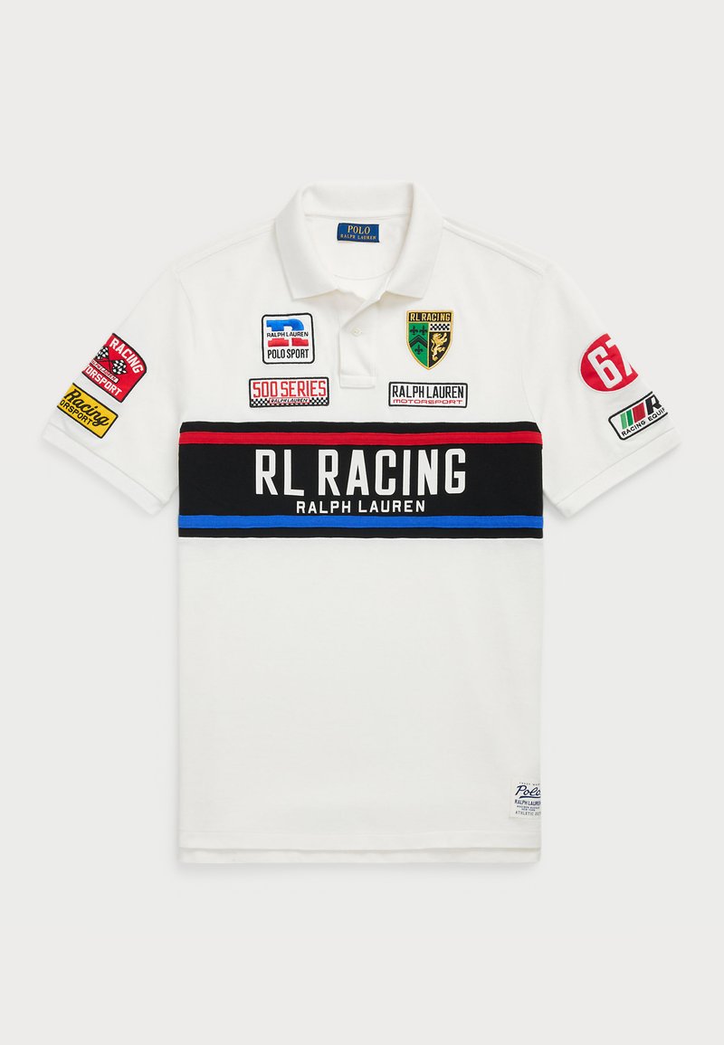 Polo-shirt blanc à manches courtes, avec une rayure horizontale noire et rouge. Orné de plusieurs patchs et logos colorés.