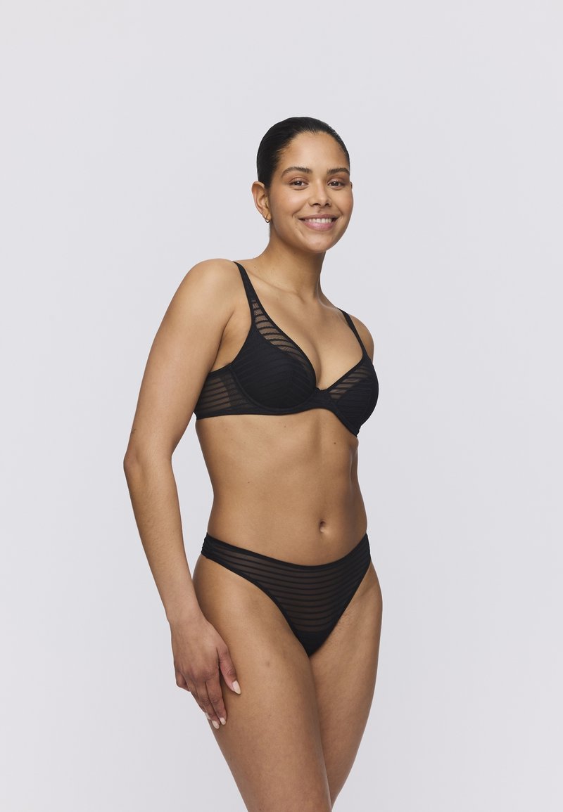 Musta alusvaatesetti, joka sisältää raidallisen rintaliivimallin säädettävillä olkaimilla ja yhteensopivat korkeavyötäröiset alushousut, korostaen tyylikästä, minimalista suunnittelua.