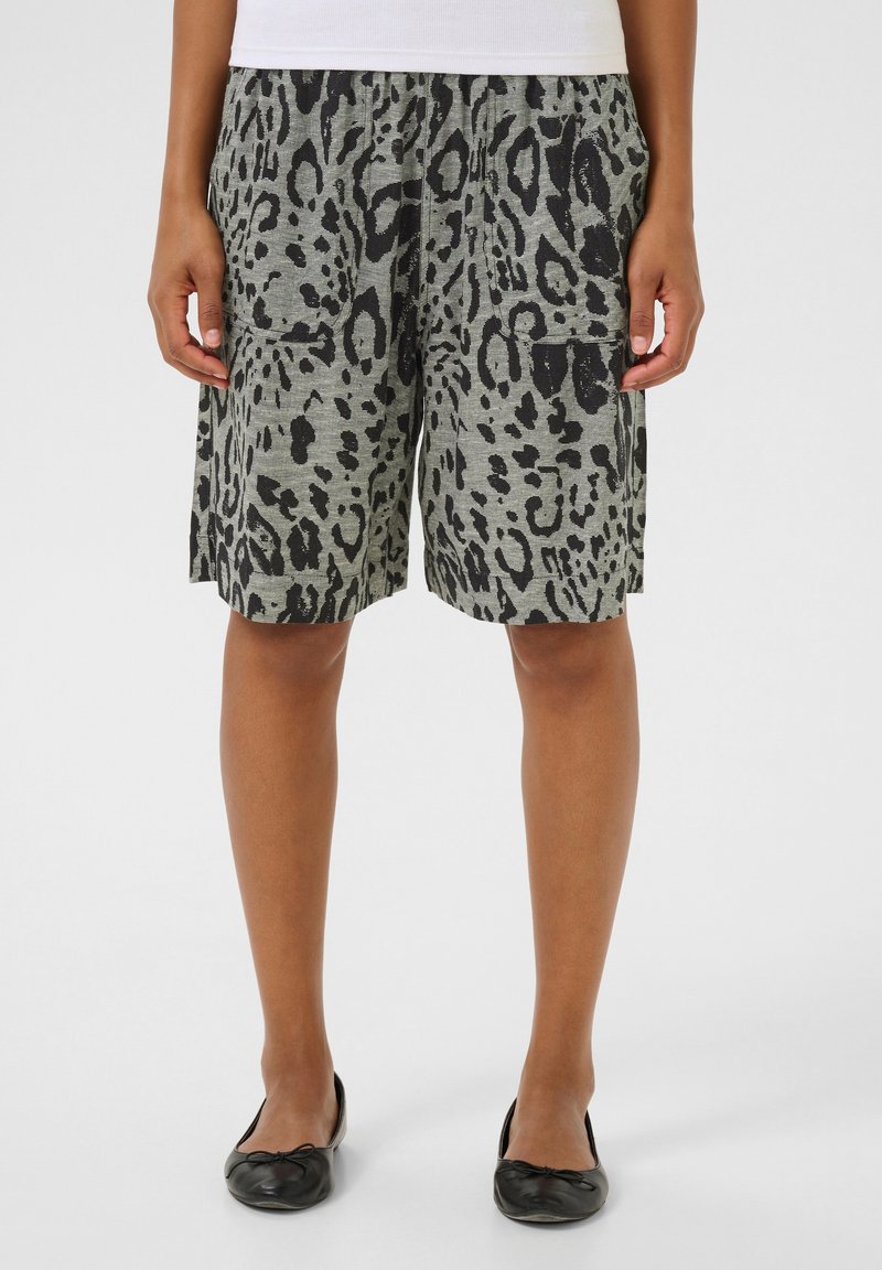 Pantalones cortos de leopardo gris con una cinturilla elástica, dos bolsillos laterales, corte relajado y tejido texturizado. Llevados con bailarinas negras.