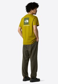 The North Face M SS BOX NSE TEE - Camiseta estampada - deep dijon woodland gre